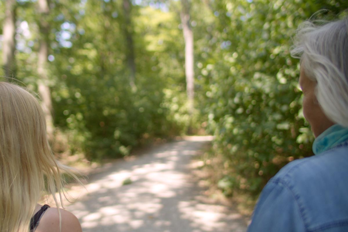 Elke Fischer-Wagemann von hinten im Gespräch mit einer Klientin beim Spaziergang durch den Wald als Symbolbild für das Angebot Einzelcoaching.